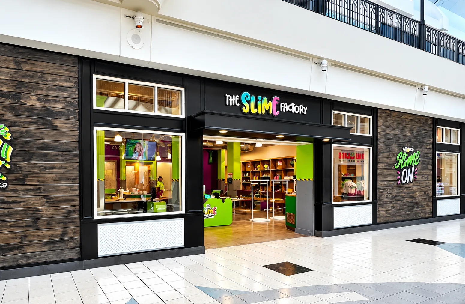 The Slime Factory entrance at North Point Mall, with a black storefront, rainbow sign and windows looking into the lab.