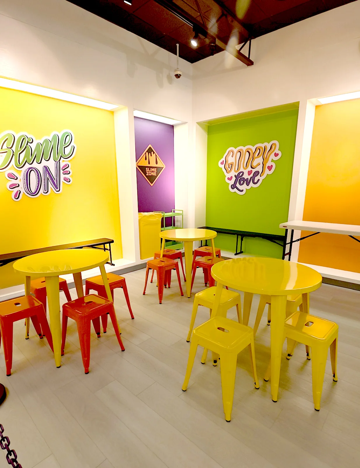 Pembroke Pines’ small party area with round yellow tables and yellow and red stools.
