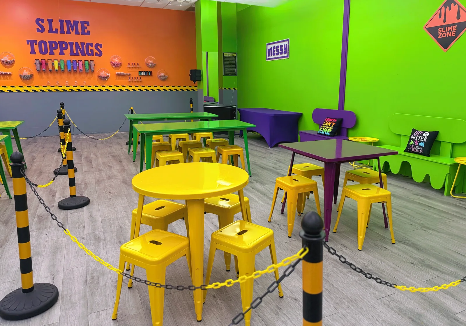 Wellington’s single party area, with lime-green walls, colorful tables and benches, yellow stools and an orange slime-toppings wall.